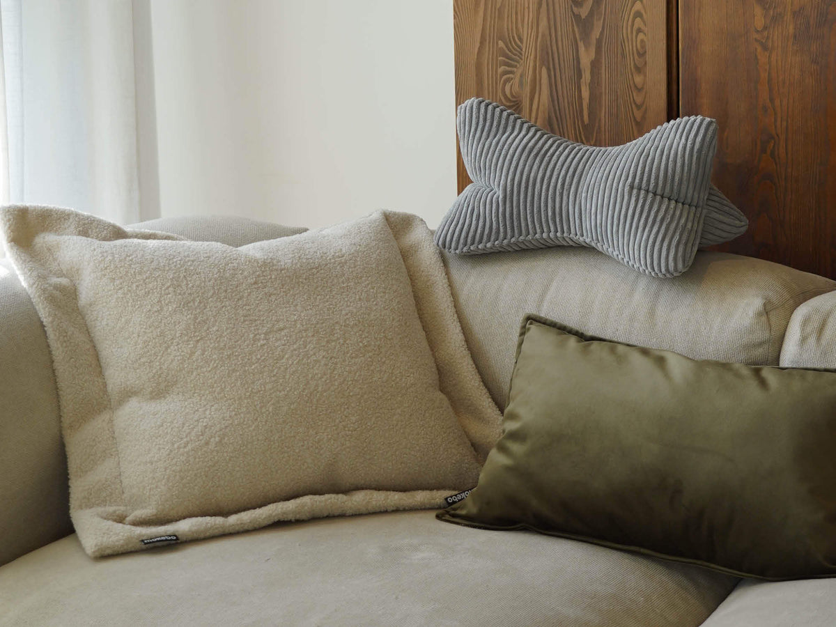 Bouclé Kissen 'Laze', Samtkissen 'Rest' und Cord Nackenkissen 'Nook' zusammen auf einem Sofa