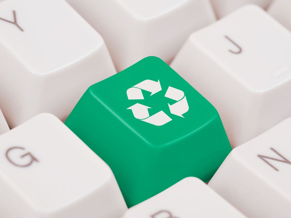 Touches d'un clavier, une touche est verte avec un symbole de recyclage blanc dessus